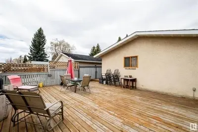 a wooden deck with chairs and tables and a house at All what you need in a House near GrayNuns, Millwoods in Edmonton