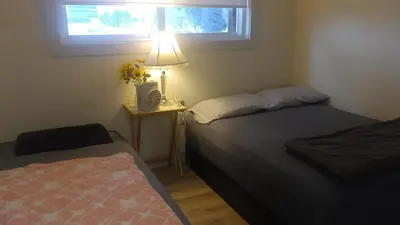 a bedroom with two beds and a table with a lamp at Vancouver Downtown Guest House- Walk to Skytrain & BC Place- Free Parking in Vancouver