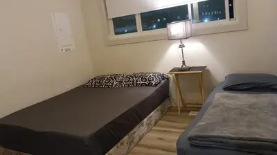 a bedroom with two beds and a lamp on a table at Vancouver Downtown Guest House- Walk to Skytrain & BC Place- Free Parking in Vancouver