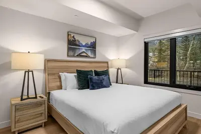a bedroom with a large bed and a window at King Beds Fire Place New Build in Canmore