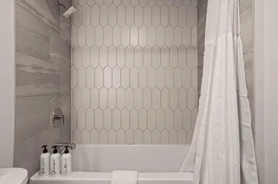 a bathroom with a white tub and a shower curtain at King Beds Fire Place New Build in Canmore