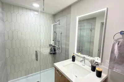 a bathroom with a sink and a shower at 3 Sisters Mountain Getaway | Luxe 2BR w Pool & Gym in Canmore