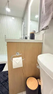 a small bathroom with a toilet and a sink at 3 Sisters Mountain Getaway | Luxe 2BR w Pool & Gym in Canmore