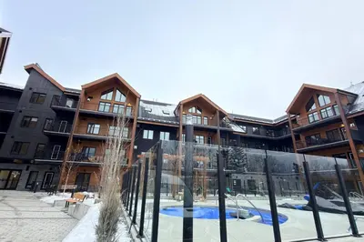 an apartment building with a playground in front of it at 3 Sisters Mountain Getaway | Luxe 2BR w Pool & Gym in Canmore