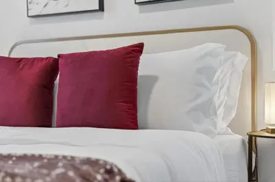 a white bed with red and white pillows at luxury Play House Sleeps 12 Keswick in Edmonton