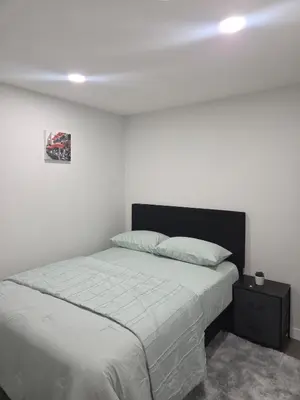 a bedroom with a bed and a picture on the wall at Cozy Suite Near West Edmonton Mall in Edmonton