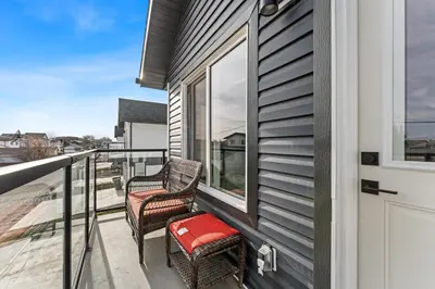 two chairs on the balcony of a house at Modern garden suite with parking in Edmonton