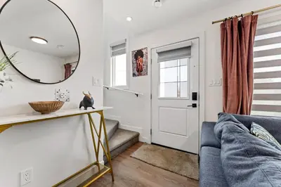 a living room with a blue couch and a mirror at Modern garden suite with parking in Edmonton