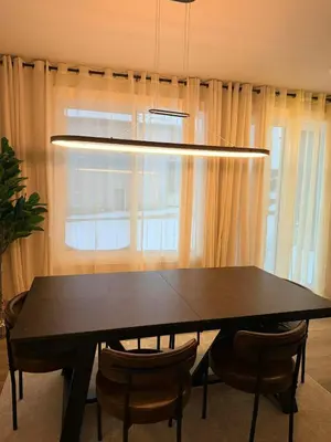 a dining room table with chairs in front of a window at Cozy and Family-friendly Newly built 3BR Home in Chestermere