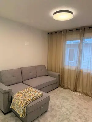 a living room with a couch and a window at Cozy and Family-friendly Newly built 3BR Home in Chestermere