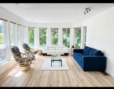 a living room with a blue couch and chairs at Ships Point Wellness INC in Fanny Bay