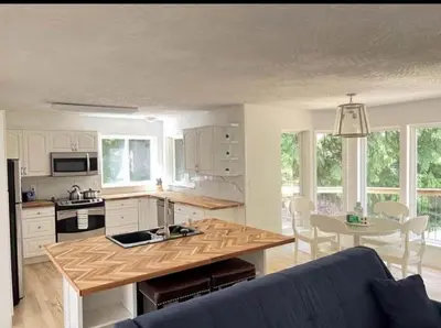 a kitchen with a blue couch and a table at Ships Point Wellness INC in Fanny Bay
