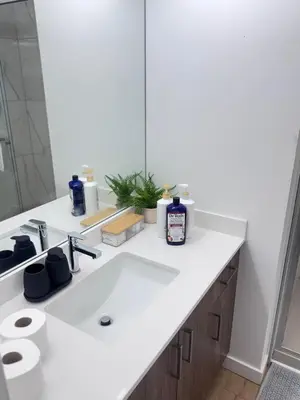 a bathroom with a white sink and a mirror at Cozy 1-Bedroom with Natural lights in Edmonton