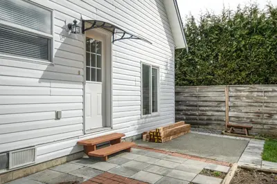a porch with a bench next to a house at The Loft at Marble Place a Cozy Family Retreat in Courtenay