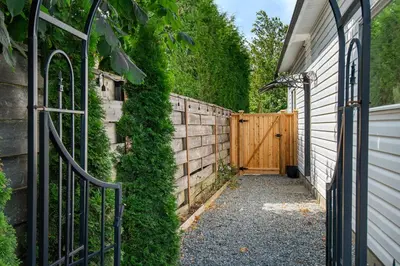 an entrance to a house with a fence and a gate at The Loft at Marble Place a Cozy Family Retreat in Courtenay