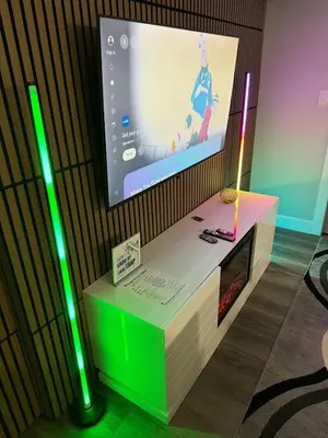 a flat screen tv on a wall with green lights at True Haven Deluxe in Prince George