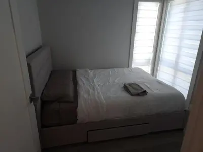 a bedroom with a bed and a chair and a window at Vancouver Family Condo 2 Bedrooms 2 Baths Near UBC & Parks in Vancouver