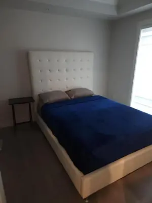 a bedroom with a large bed with a blue blanket at Vancouver Family Condo 2 Bedrooms 2 Baths Near UBC & Parks in Vancouver