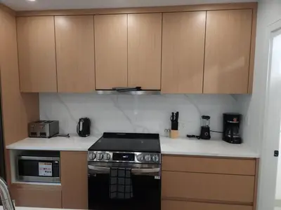 a kitchen with a stove and wooden cabinets at Vancouver Townhouse Family-Friendly with Street Parking & Balcony in Vancouver