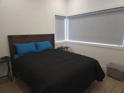 a bedroom with a bed with blue pillows and a window at Vancouver Townhouse Family-Friendly with Street Parking & Balcony in Vancouver