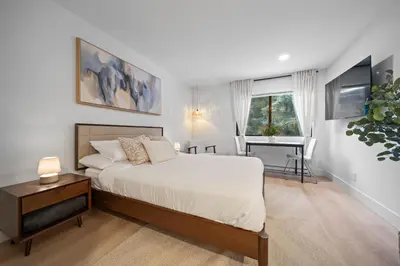 a bedroom with a bed and a desk and a window at The Alpine Alcove w Pool & Hot Tub in Whistler