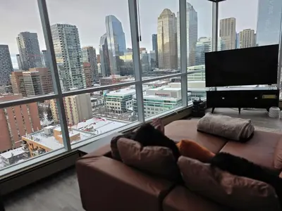 a living room with a couch and a large window at Breath-Taking-View-5 Guest DTskyline-18th Floor in Calgary