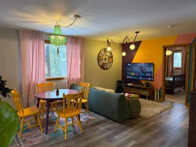 a living room with a table and a couch at Bragg Creek Vacation Estate with hot tub, sauna, pool table, karaoke, private pond and forest trails in Bragg Creek