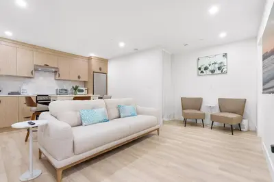 a living room with a couch and a kitchen at NEW Cambie Village 2 Bed Suite Near Skytrain in Vancouver
