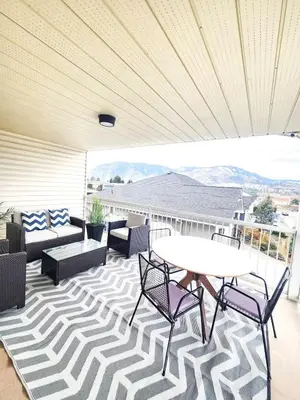a patio with a table and chairs on a balcony at Modern Lake City Getaway in Penticton