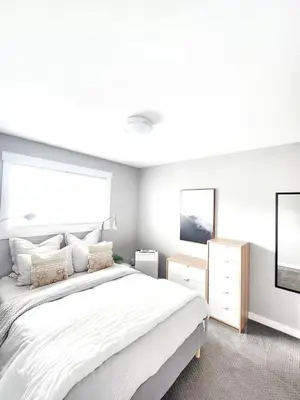 a white bedroom with a large bed and a window at Modern Lake City Getaway in Penticton