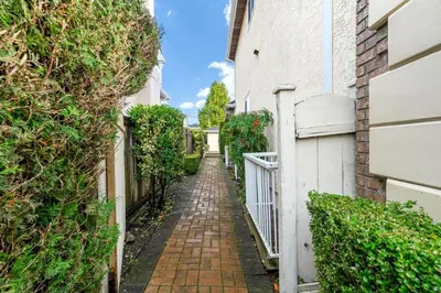 an alley way between two buildings with bushes at Comfortable Family Home,South Granville in Vancouver