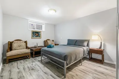 a bedroom with a bed and a chair at Comfortable Family Home,South Granville in Vancouver