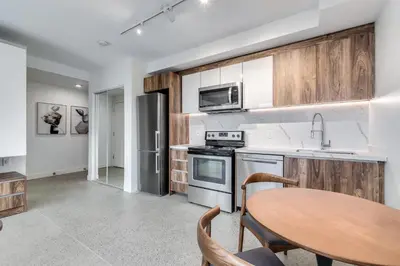 a kitchen with wooden cabinets and a wooden table at Modern Downtown Studio Bedroom Walk Everywhere in Vancouver