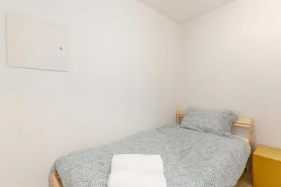 a small bedroom with a bed and a yellow cabinet at Downtown Suite with Parking, Pool, Gym in Vancouver