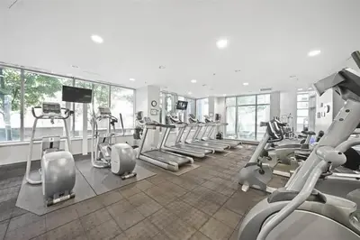 a gym with a bunch of treadmills and machines at Downtown Suite with Parking, Pool, Gym in Vancouver