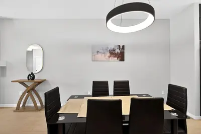 a dining room with a table and black chairs at modern 3bedroom space sleeps 6 free parking in Edmonton