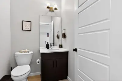 a bathroom with a toilet and a sink and a door at modern 3bedroom space sleeps 6 free parking in Edmonton