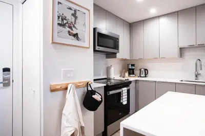a kitchen with white cabinets and a black stove top oven at The Ceili Cottage in Mackenzie Village in Revelstoke