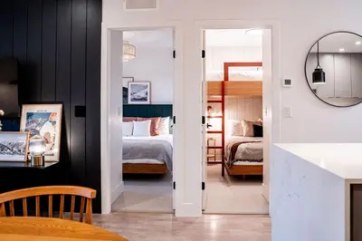 a bedroom with two beds and a mirror at The Ceili Cottage in Mackenzie Village in Revelstoke