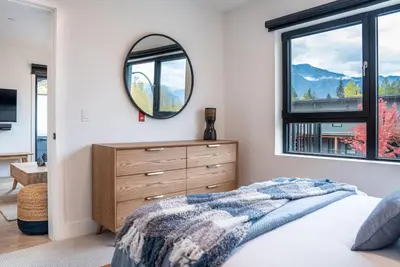 a bedroom with a dresser and a mirror at Bluebird Daze in Mackenzie Village in Revelstoke