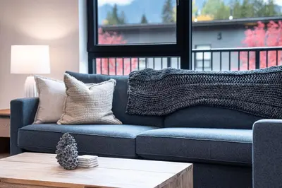 a blue couch in a living room with a table at Bluebird Daze in Mackenzie Village in Revelstoke
