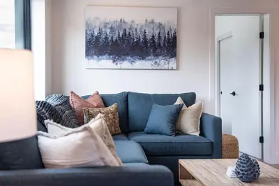 a living room with a blue couch with pillows at Bluebird Daze in Mackenzie Village in Revelstoke