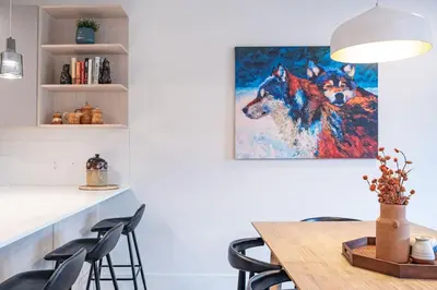 a dining room with a painting of two dogs at Bluebird Daze in Mackenzie Village in Revelstoke