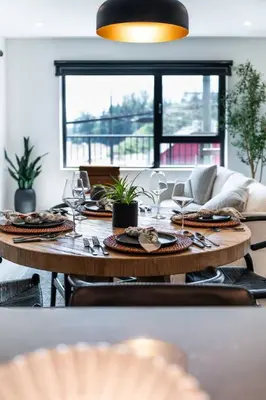 a wooden table with plates and wine glasses on it at Alpine Ascent with Hot Tub in Mackenzie Village in Revelstoke