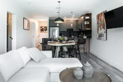 a living room and kitchen with a white couch and a table at Alpine Ascent with Hot Tub in Mackenzie Village in Revelstoke