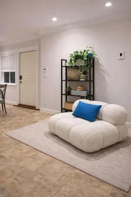 a large white couch with a blue pillow on a rug at Luxury New 2BR Private Suite In Vancouver West Full Kitchen in Vancouver