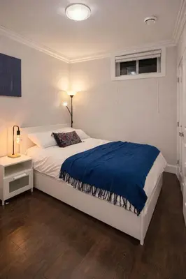 a bedroom with a white bed with a blue blanket at Luxury New 2BR Private Suite In Vancouver West Full Kitchen in Vancouver