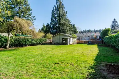 a large yard with a house in the background at Quiet Furnished Room Near Transit and Hospital long stays in Surrey