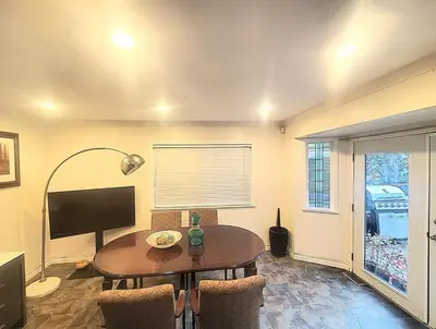 a living room with a table and a television at Quiet Furnished Room Near Transit and Hospital long stays in Surrey
