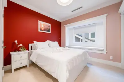 a red bedroom with a white bed and a window at An Amazing StarHouse in Westside Vancouver in Vancouver